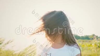 一个迷人的小女孩，长着一头飘逸的长发，她的头向不同的方向转动，风吹起了长发。